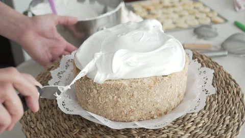 Slow motion of pastry chef's hand spreading meringue with long spatula. Stock Footage 240770448