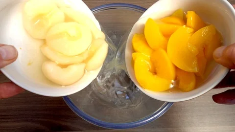Slow motion: Pear and peach slices pouring into a glass bowl. Stock Footage 90407779