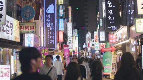 Slow motion of pedestrians walking under neon lights in Jonggak Stock Footage 314518925