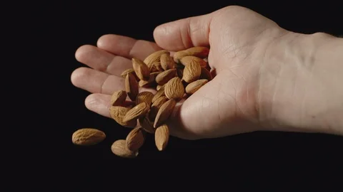 SLOW MOTION: Peeled almonds fall from man's palm - Front view Stock Footage 102212865