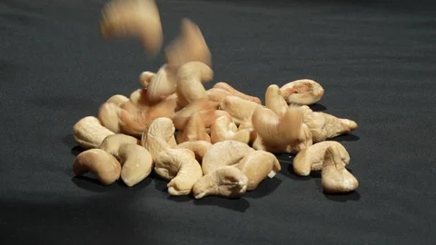 Slow Motion Peeled Cashew Nuts Falling on Black Background. Видео 333674678