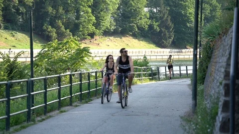 Slow motion of people going by bike and making jogging at the park Stock Footage