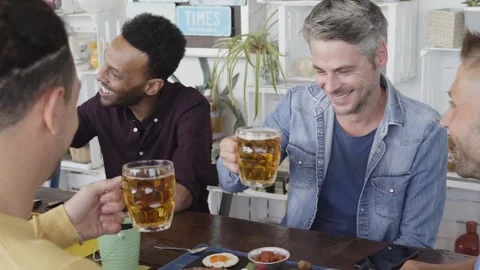 Slow motion. People having fun at bar. Friends taking lunch time drinking beer Stock Footage 184651903