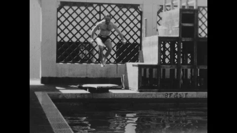 Slow motion of people jumping into a pool, united kingdom, 1932 to 1936 Stock Footage 131531192