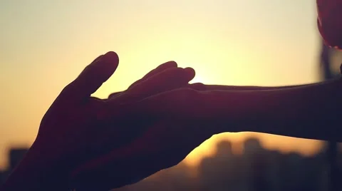 Slow motion of people in love holding hands at sunset on blurred silhouette of Stock Footage