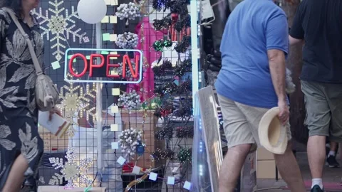 Slow motion of people passing vibrant neon signs near market entrance Stock Footage 314072855