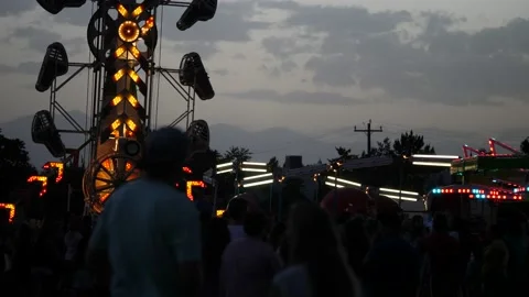 Slow motion of people waiting in lines for fun carnival rides at night Stock Footage 148201454