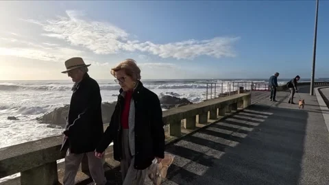 Slow-motion people walking along the promenade near the Atlantic Ocean Stock Footage 255291029