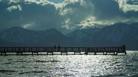 Slow motion people walking on peer on lake with clouds and mountains Stock Footage 109260360