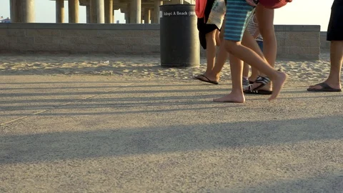 Slow motion people walking on sunset beach Stock Footage