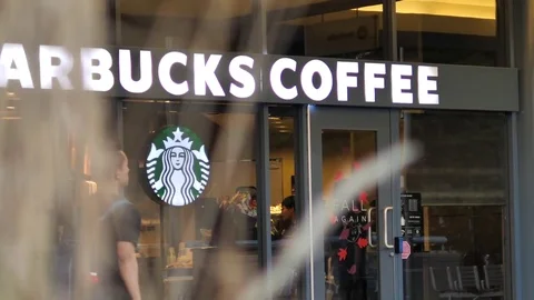 Slow motion of people walking through starbucks store Stock Footage 80108890