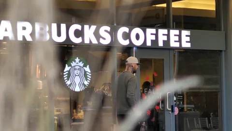 Slow motion of people walking through starbucks store Video stock 80133549