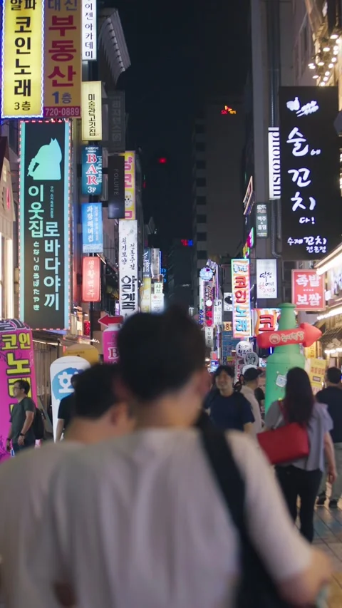 Slow motion of people walking through neon-lit Jonggak street at night Stock Footage 315465276