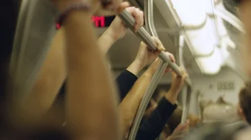 Slow motion of people's hands holding onto railings inside a moving train Stock Footage 85581874