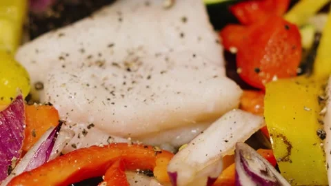 Slow motion pepper granules falling on wild caught atlantic Cod fillets in Stock Footage 331275561