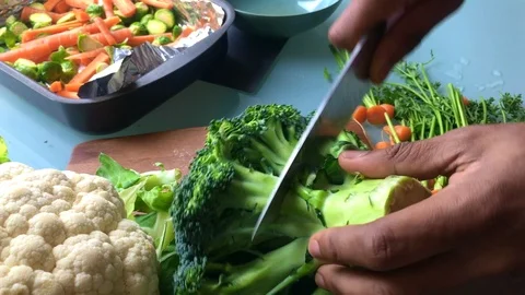 Slow motion of person chopping broccoli for vegan dish - 15 sec Stock Footage 126909582