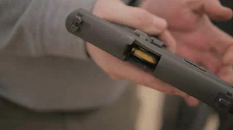 Slow Motion Person Inserts a Magazine Full of Ammo into a Semi Automatic Handgun Stock Footage 60690011