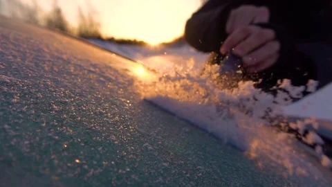 SLOW MOTION: Person scraping morning frost off a car window on winter morning Stock Footage