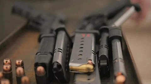 Slow Motion Person Setting Down Empty Magazine Next to Loaded Magazines Stock Footage 60689855