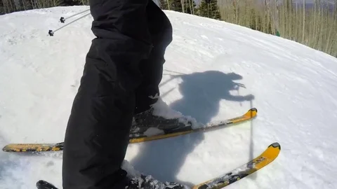 Slow motion of a person skiing on a sunny day at Utah mountain ski resort Stock Footage