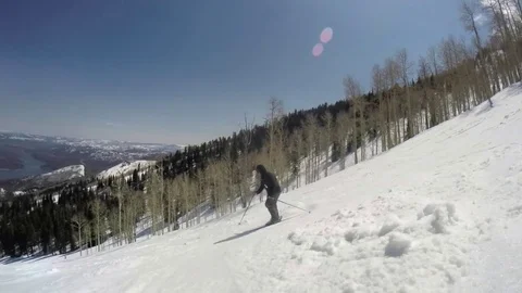 Slow motion of a person skiing on a sunny day at Utah ski resort Stock Footage