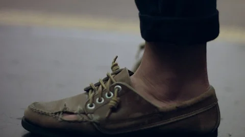 Slow motion of person's broken shoe as he waits at a subway station Stock Footage 85578632