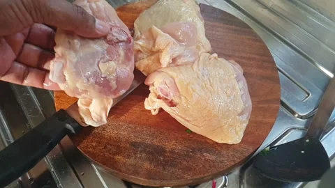 Slow motion of piece of meat or chicken put on wooden chopping board with knife. Video stock 130287034