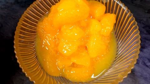 Slow motion – Pieces of mandarin orange pouring into a glass bowl. Video stock 103528741