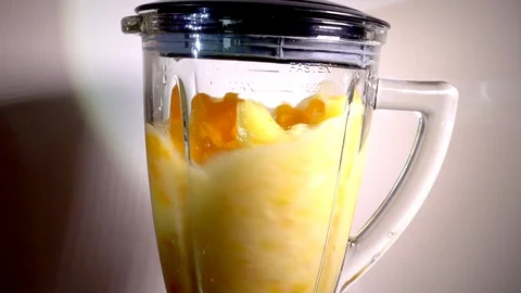 Slow motion – pineapple, mandarin oranges and apple being mixed in a blender. Stock Footage 102032079