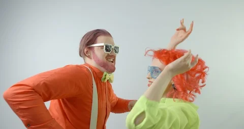 Slow motion of pink head man in orange shirt is throwing the confetti while Stock Footage 88037177