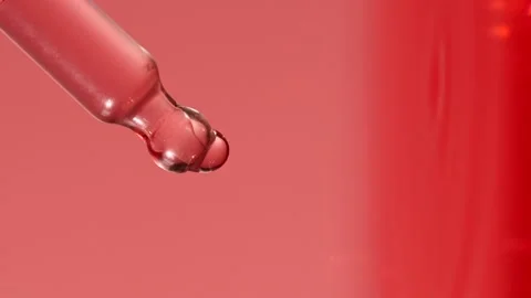 Slow motion of pink serum fluid, oil drop falling from dropper, pipette in water Stock Footage 196204482