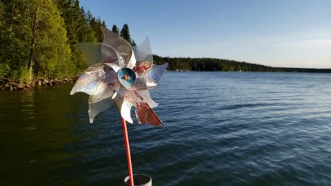 Slow Motion Pinwheel blowing in the wind on a dock on Child's Lake, Manitoba Stock Footage 122151424