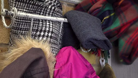 Slow motion – Placing a winter hat and scarf on a coat rack. Video stock 131139687
