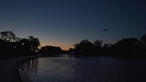 Slow motion plane flying overhead at night above River Torrens Stock Footage 102871802
