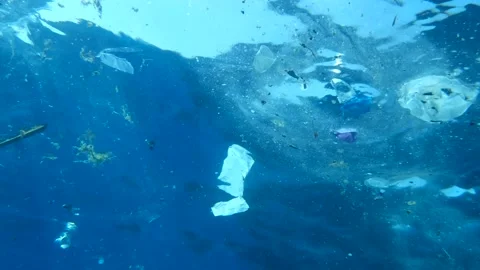 Slow motion, Plastic and other garbage slowly drifting on the blue water surface Stock Footage 143476151