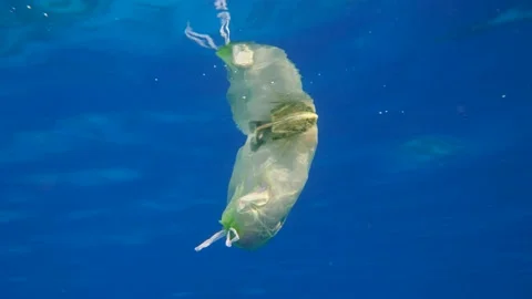 Slow motion, a plastic bag filled with plastic and other debris drifting slowly Stock Footage 142932577