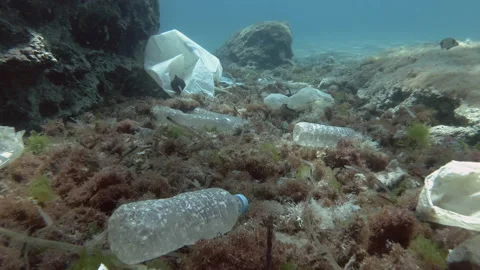 Slow motion. Plastic pollution of the ocean bottom, tropical fishes swims above Stock Footage 167125919