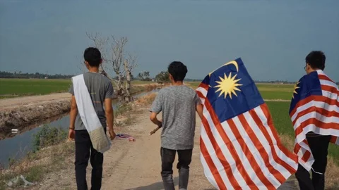 Slow motion playful of three young man with Malaysia flag. Independent Day. Stock Footage 94009825