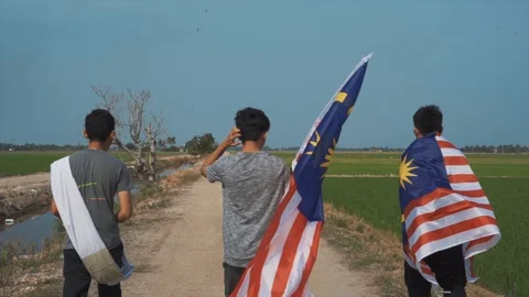 Slow motion playful of three young man with Malaysia flag. Independent Day. Stock Footage 94010024