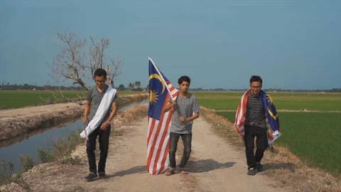Slow motion playful of three young man with Malaysia flag. Independent Day. Stock Footage 94010756