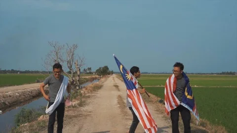 Slow motion playful of three young man with Malaysia flag. Independent Day. Stock Footage 94010852