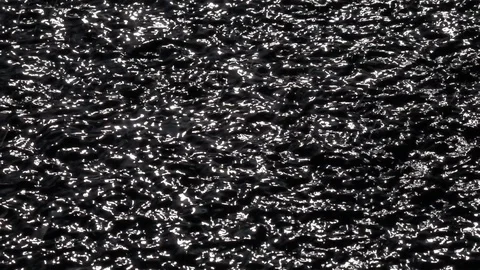 Slow motion of playing sun shine reflection on black water ripple. Stock Footage 99144104