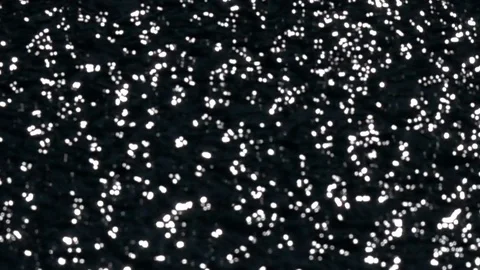 Slow motion of playing sun shine reflection on black water ripple. Stock Footage 99145317