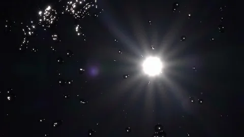 Slow motion of playing water on dark sky with shining sun and lens flare. Stock Footage 100237015