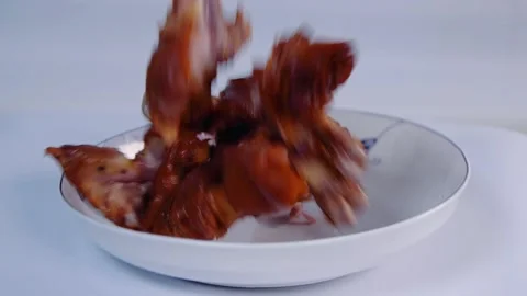 Slow motion pork droping into plate Video stock 169071199