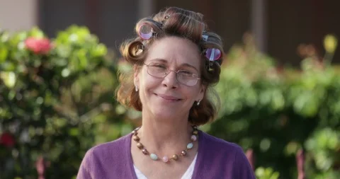 Slow Motion Portrait Close Up Smiling Senior Woman With Hair Rollers Stock Footage 128718576