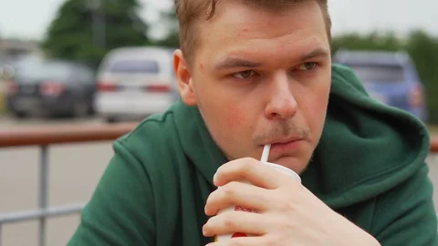 Slow motion portrait close up of a Young man who drinks soda Stock Footage 91231047