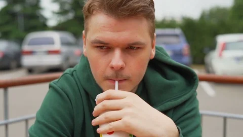 Slow motion portrait close up of a Young man who drinks soda Stock Footage 91231051