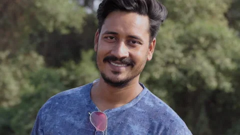 Slow motion portrait of a handsome young indian man looking at camera, smiling Stock Footage 150687083