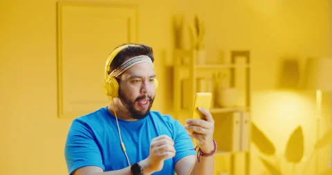Slow motion portrait of happy bearded young man with headphone and celebrating Stock Footage 165870045